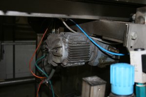 Le garde protecteur du ventilateur de refroidissement du moteur électrique de la motorisation de cet équipement n’a pas été remis en place de sorte que le ventilateur est en train de détruire le câblage que l’on distingue en bleu, en rouge et en noir. De plus, il y a surchauffe du moteur électrique. Les roulements portent le suffixe C3, ce qui signifie que les roulements DE & NDE (drive end et non drive end) ont un jeu interne plus grand que la normale. Ceci est tout à fait correct, car, lorsque le moteur a atteint sa température de fonctionnement, comme le rotor est plus chaud que le stator qui lui est normalement refroidi par l’air pulsé par le ventilateur, les jeux mécaniques dans les roulements redeviennent normaux, car la couronne intérieure des roulements est plus chaude que les couronnes extérieures. Dans notre cas, le jeu interne reste plus grand que la normale, car le stator n’est pas refroidi, ce qui entraîne une vibration parasite qui va détruire les roulements et possiblement le moteur considérant qu’il est haute efficacité et que dans ce cas, la distance entre le rotor et le stator est réduite. Le réducteur perd également de l’huile.